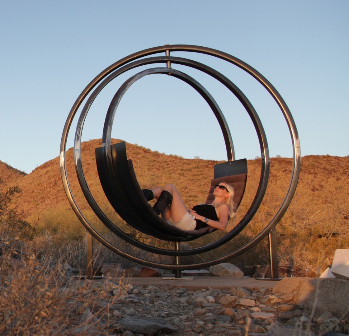 Woman reclining inside outdoor circular sculpture